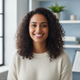 Portrait of a smiling South Asian woman in her late 20s, looking at the camera with a happy, satisfied expression. She is in 